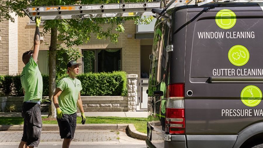 On the job site, the Umbrella Team unloads a ladder from their van